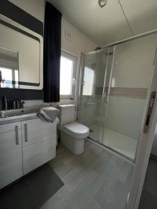 a bathroom with a toilet and a glass shower at Hollers Holiday Homes Haus Oli in Drage
