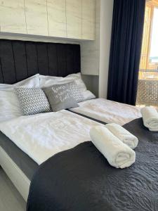 a bed with two white towels on top of it at Hollers Holiday Homes Haus Oli in Drage