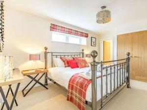 um quarto com uma cama com almofadas vermelhas em Stags Barn Saxon Maybank em Sherborne