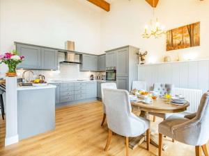a kitchen with a table and chairs in a room at Stags Barn Saxon Maybank in Sherborne