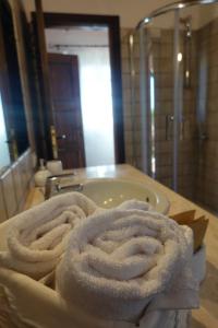 einen Haufen Handtücher auf einer Theke im Bad in der Unterkunft Stazzu Barecca B&B in Cugnana Verde