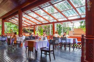 a group of people sitting at tables in a restaurant at Royal Phawadee Village Patong - 2 Minutes walk to the beach in Patong Beach