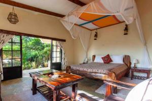 a bedroom with a bed and a table at Punda Milias Lodge in Nakuru