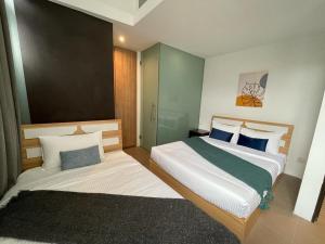 um quarto de hotel com duas camas num quarto em The Assembly Place, Hotel at Veerasamy em Singapura