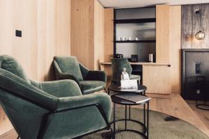 ein Wohnzimmer mit 2 Stühlen und einem Kamin in der Unterkunft Hotel Schöne Aussicht in Sölden