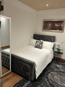 a bed with a black headboard in a bedroom at TJ Homes - Entire place for 5 Guests - London in Ruislip