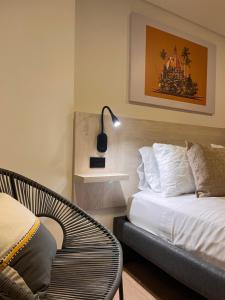 1 dormitorio con 1 cama, 1 silla y 1 lámpara en Pereira Endless Green Condo., en Pereira