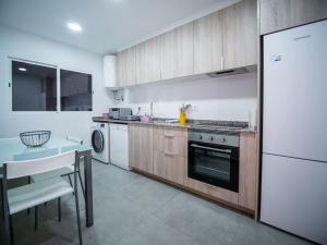 a kitchen with wooden cabinets and a white refrigerator at AC Apartments Germanías in Valencia