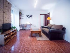 - un salon avec un canapé et une table dans l'établissement AC Apartments Germanías, à Valence