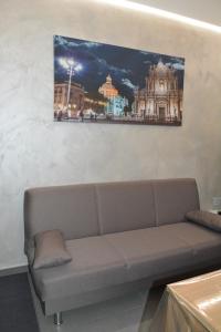 un sofá en una habitación con una foto en la pared en House SantaFè2, en Catania