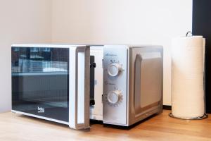 a microwave and a toaster oven sitting on a floor at Stay and Work Apartment - 6 single beds in Bocholt +20 photos