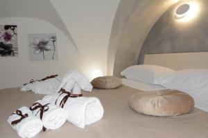 Habitación con 3 camas, toallas y almohadas blancas. en House SantaFè2, en Catania