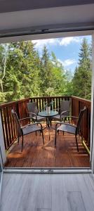 a patio with a table and chairs on a deck at Apartament Eden Chopina in Karpacz