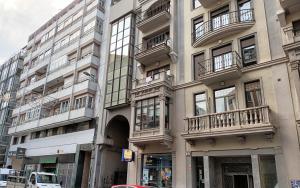 een hoog gebouw met balkons aan de zijkant bij La casa de los abedules in León