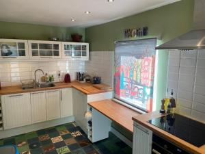 a kitchen with white cabinets and a painting on the wall at La Bruyere du Coq Stables in Sart-Dames-Avelines