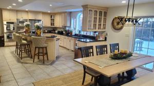 une cuisine avec une grande île et une table dans l'établissement Hilltop Mansion at Rebecca's Fountain, à Niskayuna