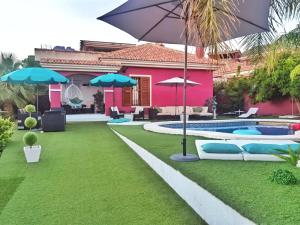 a backyard with a pool and a house with an umbrella at Stag hendo25pax DESPEDIDAS 25 personas piscina privada consultar precio in Benidorm