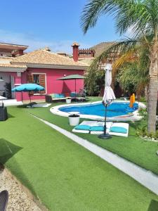 a yard with a pool and a umbrella and a house at Stag hendo25pax DESPEDIDAS 25 personas piscina privada consultar precio in Benidorm