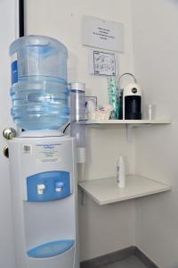 un frigorifero con un grande contenitore d'acqua in cima di A San Lazzaro Rooms a San Lazzaro di Savena