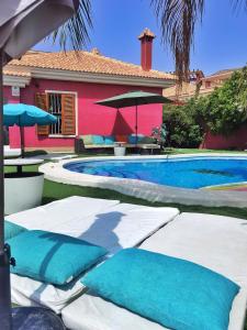 a swimming pool with blue pillows next to a house at Stag hendo25pax DESPEDIDAS 25 personas piscina privada consultar precio in Benidorm
