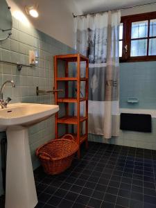 baño con lavabo y cortina de ducha en Coumenios, en Moulis