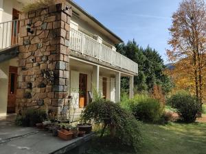 una casa de piedra con un balcón en un lateral. en Coumenios, en Moulis