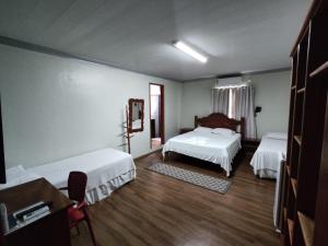 a hotel room with two beds and a table at Raludi Hotel in Barcarena