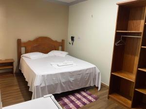 a bedroom with a bed with a wooden head board at Raludi Hotel in Barcarena