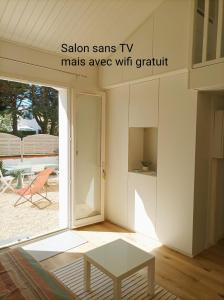 a living room with a table and a view of a patio at Maison Bord de mer à Noirmoutier in Barbâtre