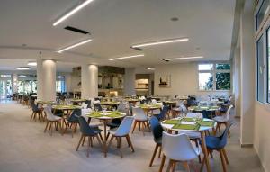 uma sala de jantar cheia de mesas e cadeiras em Aquamare Lesvos em Metímna