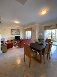 a living room with a table and chairs and a couch at Balaia Residence in Albufeira