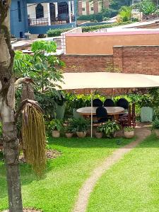 a patio with a table and chairs in a yard at Puma Garden and Suites - Nyarutarama in Kigali