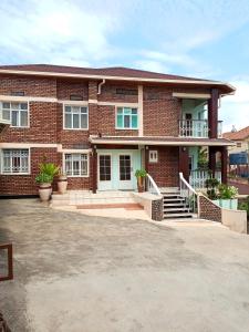 a brick house with a driveway in front of it at Puma Garden and Suites - Nyarutarama in Kigali