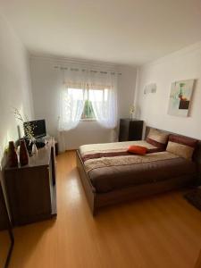a bedroom with a bed and a desk and a window at Balaia Residence in Albufeira