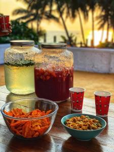 a table with two jars of honey and a bowl of nuts at Hostel Mandala in Anjuna