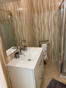 Balaia Residence في ألبوفيرا: حمام مع حوض أبيض ومرآة