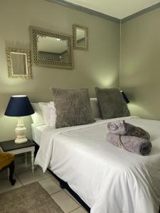 a bedroom with two beds and a lamp and a mirror at Jobe Guesthouse in Pietermaritzburg