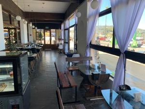 a restaurant with tables and chairs and a window at Hotel City Piriápolis in Piriápolis