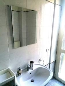 ein weißes Waschbecken in einem Badezimmer mit Spiegel in der Unterkunft Vercelli suite in Borgo Vercelli + 11 Fotos