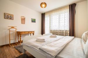 a bedroom with a white bed and a window at Viktoria B32 by Arosa Holiday in Arosa
