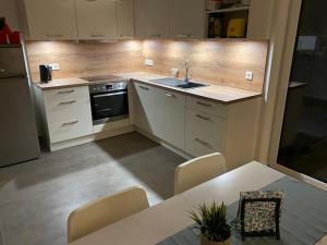 a kitchen with white cabinets and a table with chairs at Ferienwohnung Westerwald-Domizil 