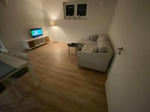 a living room with a couch and a television at Ferienwohnung Westerwald-Domizil 
