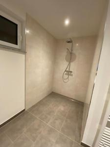 a bathroom with a shower and a tiled floor at Ferienwohnung Westerwald-Domizil 