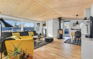 sala de estar con sofá amarillo y chimenea en Lovely Home In Broager With Kitchen, en Broager