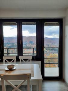 Cette chambre dispose d'une table et de fenêtres avec vue. dans l'établissement Vineyard cottage Kulovec, à Uršna Sela