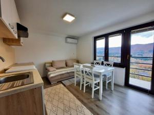 a kitchen and living room with a table and a couch at Vineyard cottage Kulovec in Uršna Sela