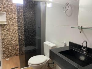 a bathroom with a white toilet and a sink at Raludi Hotel in Barcarena