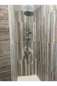 a shower in a bathroom with a tiled wall at Casa da Estrelinha in Carrapateira