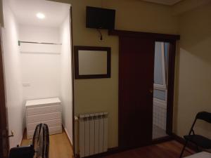 Habitación con puerta y TV en la pared en Apain HT en San Sebastián