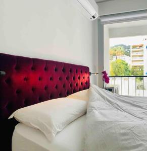 a bedroom with a red headboard and a white bed at Central, quiet & cosy apartment near Monaco in Beaulieu-sur-Mer